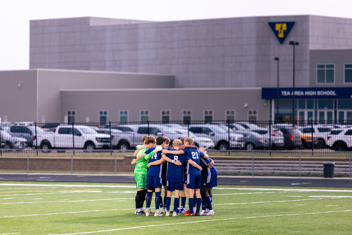 Tea Area soccer players huddling together in front of their high school